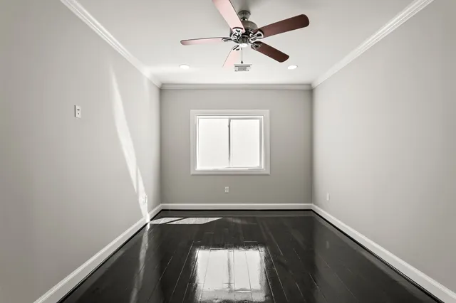 an empty room with a window and a fan