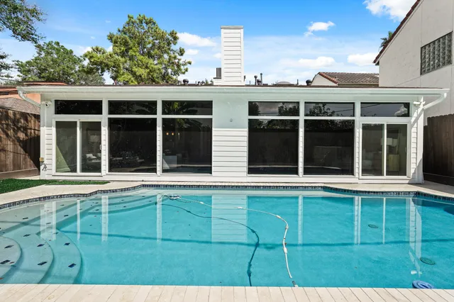 a view of a house with pool and sitting area
