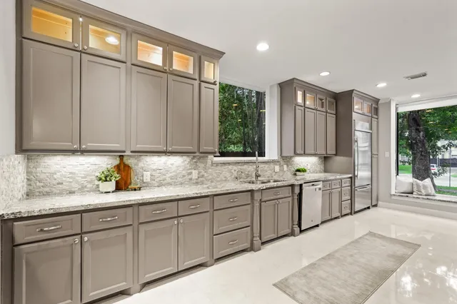 a large bathroom with a granite countertop sink and a large window