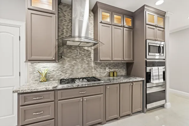 a kitchen with white cabinets and window