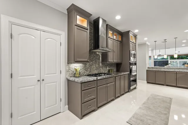 a large kitchen with stainless steel appliances granite countertop a stove a sink and a refrigerator