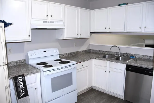 a kitchen with granite countertop white cabinets and white appliances