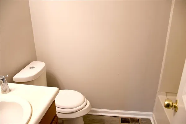 a white toilet sitting next to a white wall