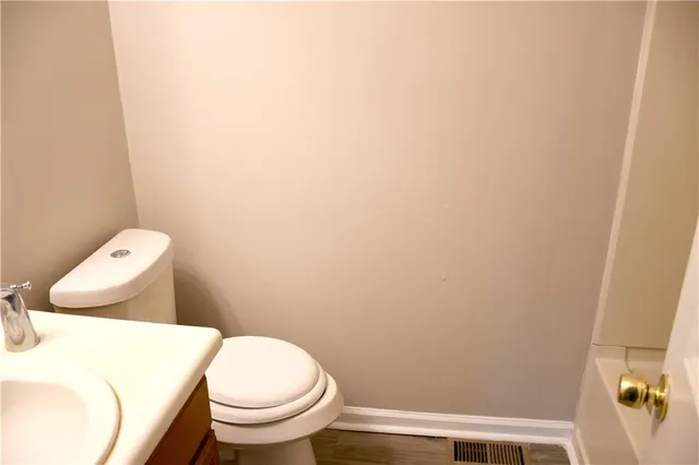 a white toilet sitting next to a white wall