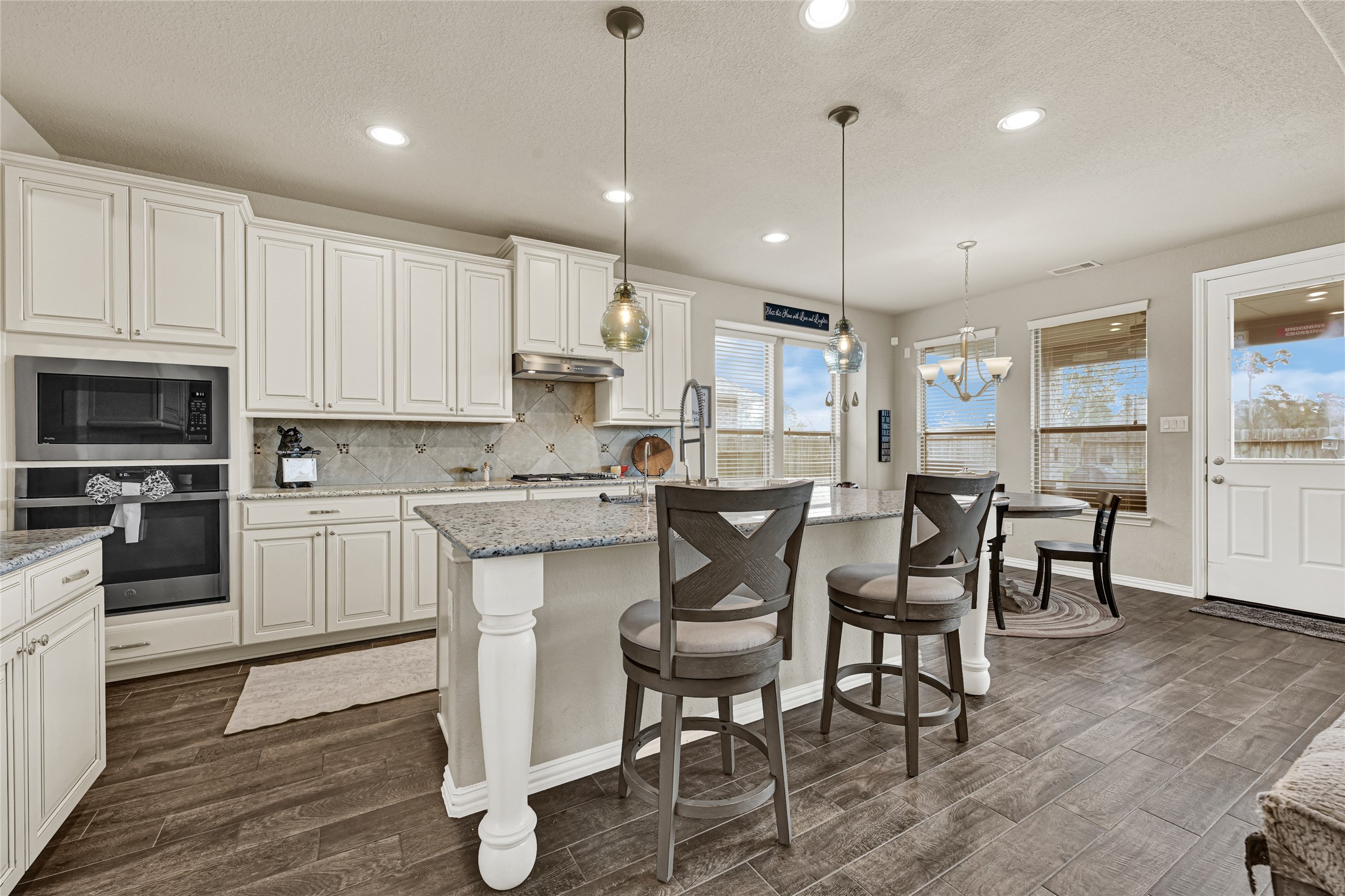 10319 Silver Shield Way Tomball, TX 77375 - Photo 13 of 46 a kitchen with kitchen island granite countertop a sink a counter space stainless steel appliances and cabinets