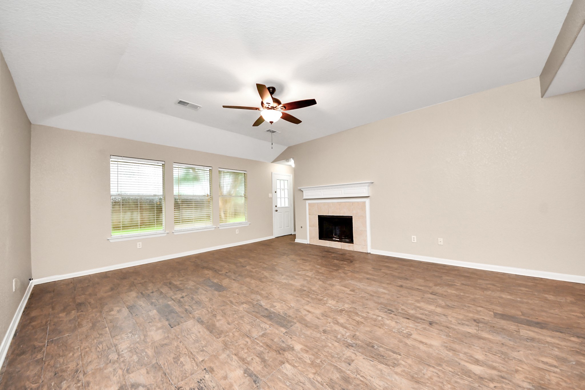 14610 Hazy Ridge Lane Cypress, TX 77429 - Photo 13 of 44 Spacious living area centered around a cozy fireplace, creating the perfect setting for relaxing evenings and gathering with family and friends.