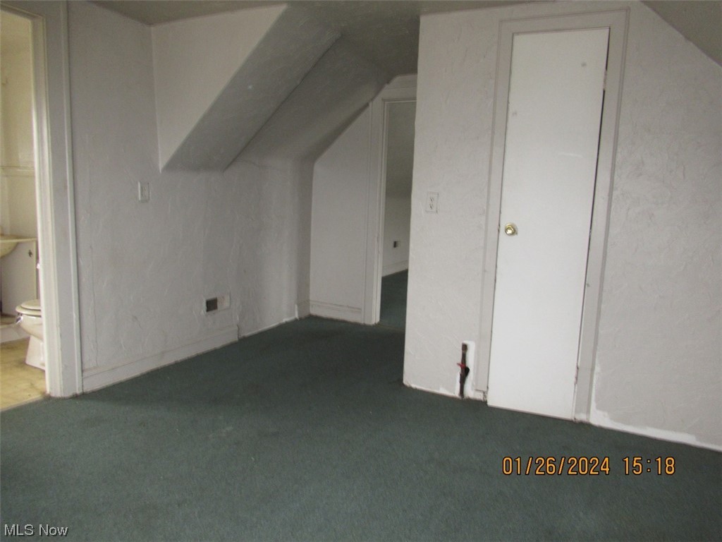 1823-1825 Reyburn Road Cleveland, OH 44112 - Photo 15 of 18 Additional living space with dark colored carpet and lofted ceiling