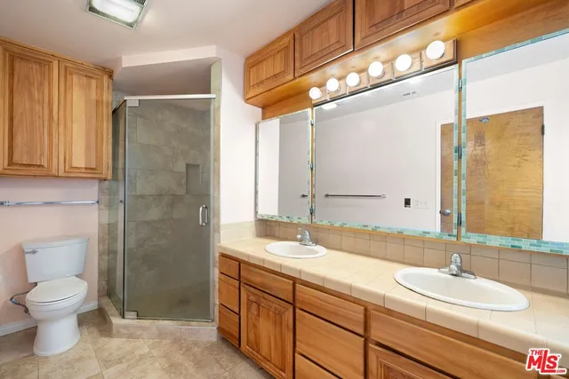 a bathroom with a granite countertop sink toilet and shower