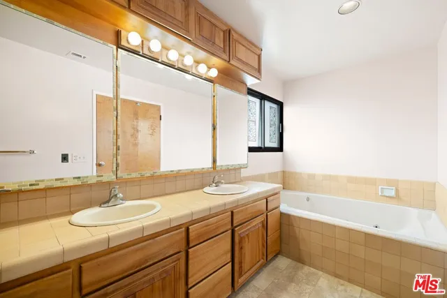 a bathroom with a granite countertop sink and a mirror