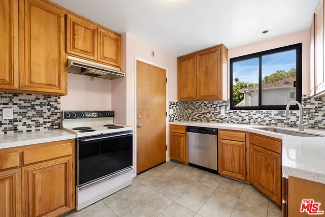 a kitchen with stainless steel appliances granite countertop a stove sink and cabinets