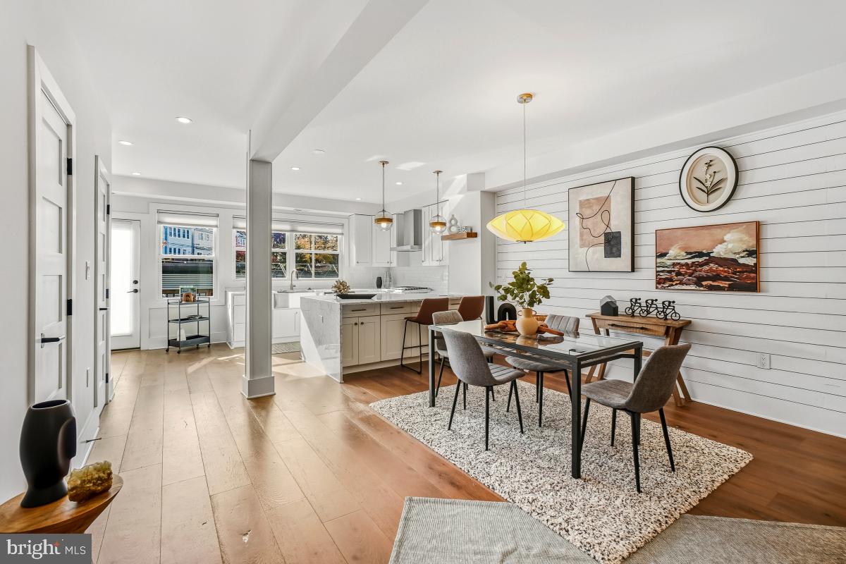 714 Decatur Street Northwest Washington, DC 20011 - Photo 10 of 40 a living room with couches a dining table and kitchen view with wooden floor
