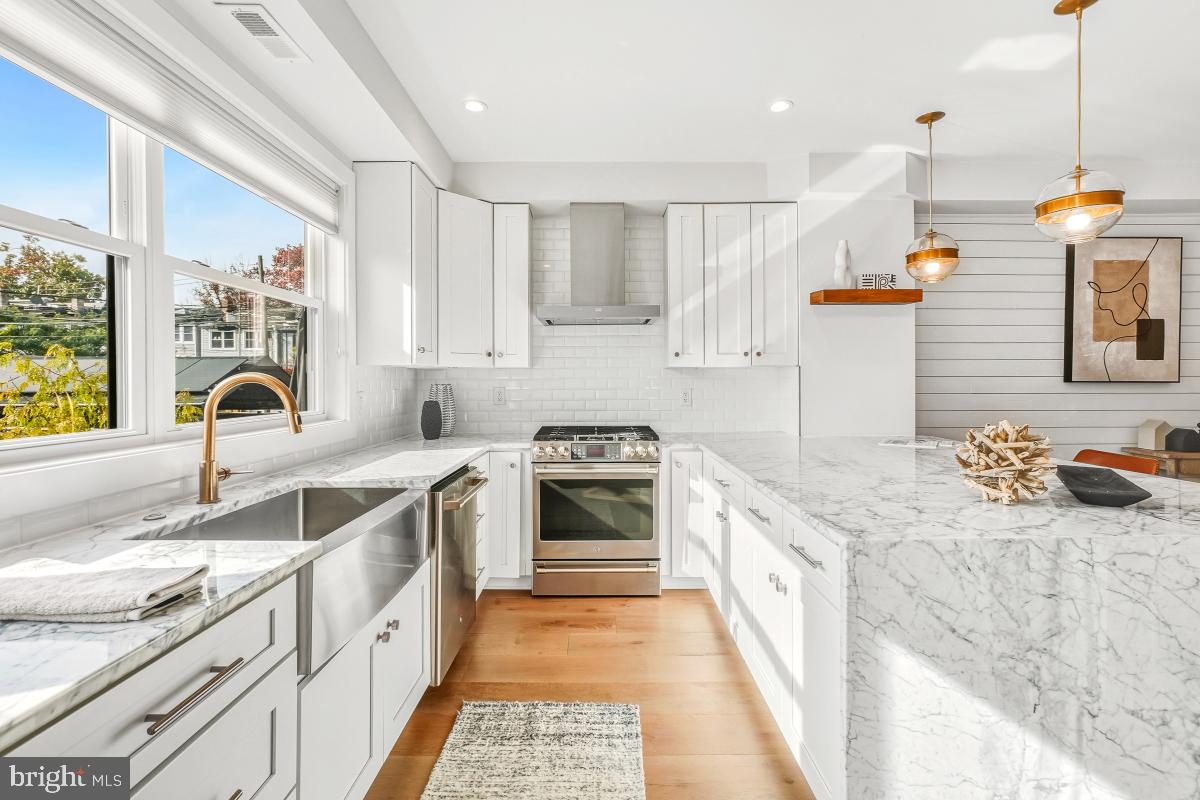 714 Decatur Street Northwest Washington, DC 20011 - Photo 15 of 40 a kitchen with stainless steel appliances granite countertop a sink stove and refrigerator