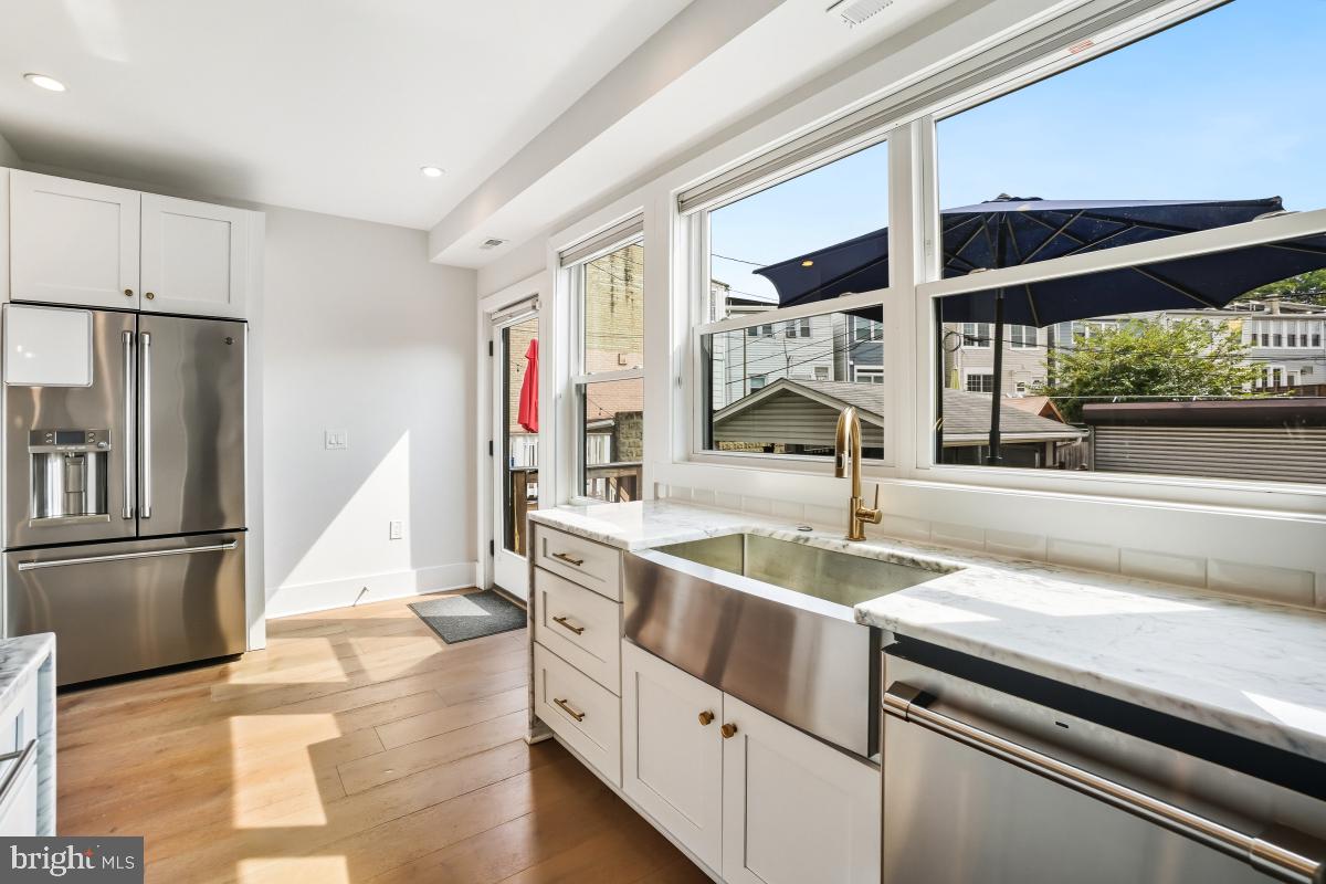 714 Decatur Street Northwest Washington, DC 20011 - Photo 17 of 40 a kitchen with stainless steel appliances granite countertop a sink and a refrigerator