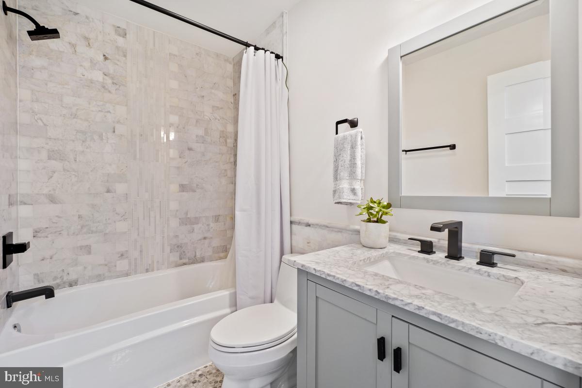 714 Decatur Street Northwest Washington, DC 20011 - Photo 25 of 40 a bathroom with a granite countertop sink a toilet and shower