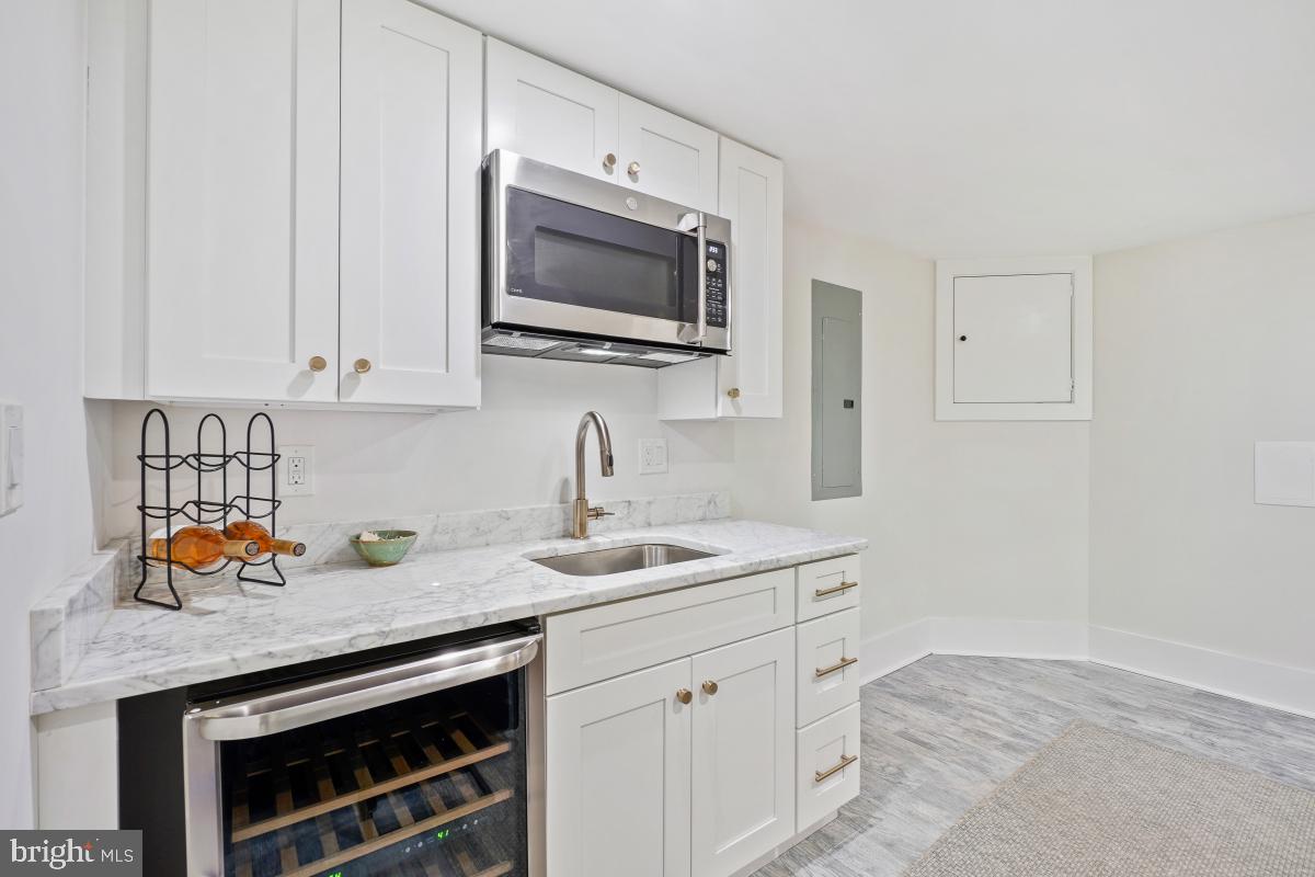 714 Decatur Street Northwest Washington, DC 20011 - Photo 29 of 40 a kitchen with stainless steel appliances granite countertop a sink stove and microwave with wooden floor