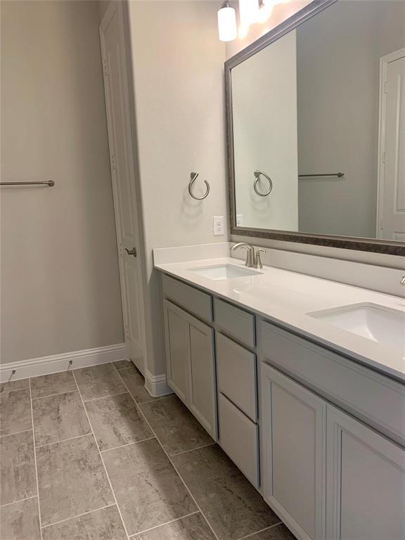 5537 Yellowstone Road The Colony, TX 75056 - Photo 9 of 25 Full bathroom with double vanity and light tile patterned flooring
