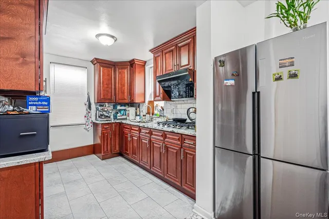 a kitchen with stainless steel appliances granite countertop a refrigerator and a stove top oven