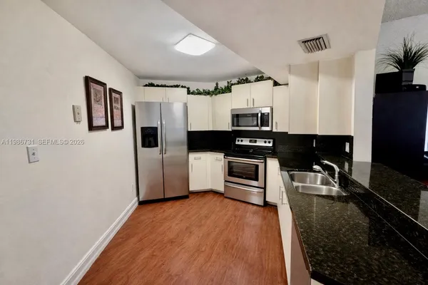 a kitchen with stainless steel appliances a refrigerator and a stove top oven