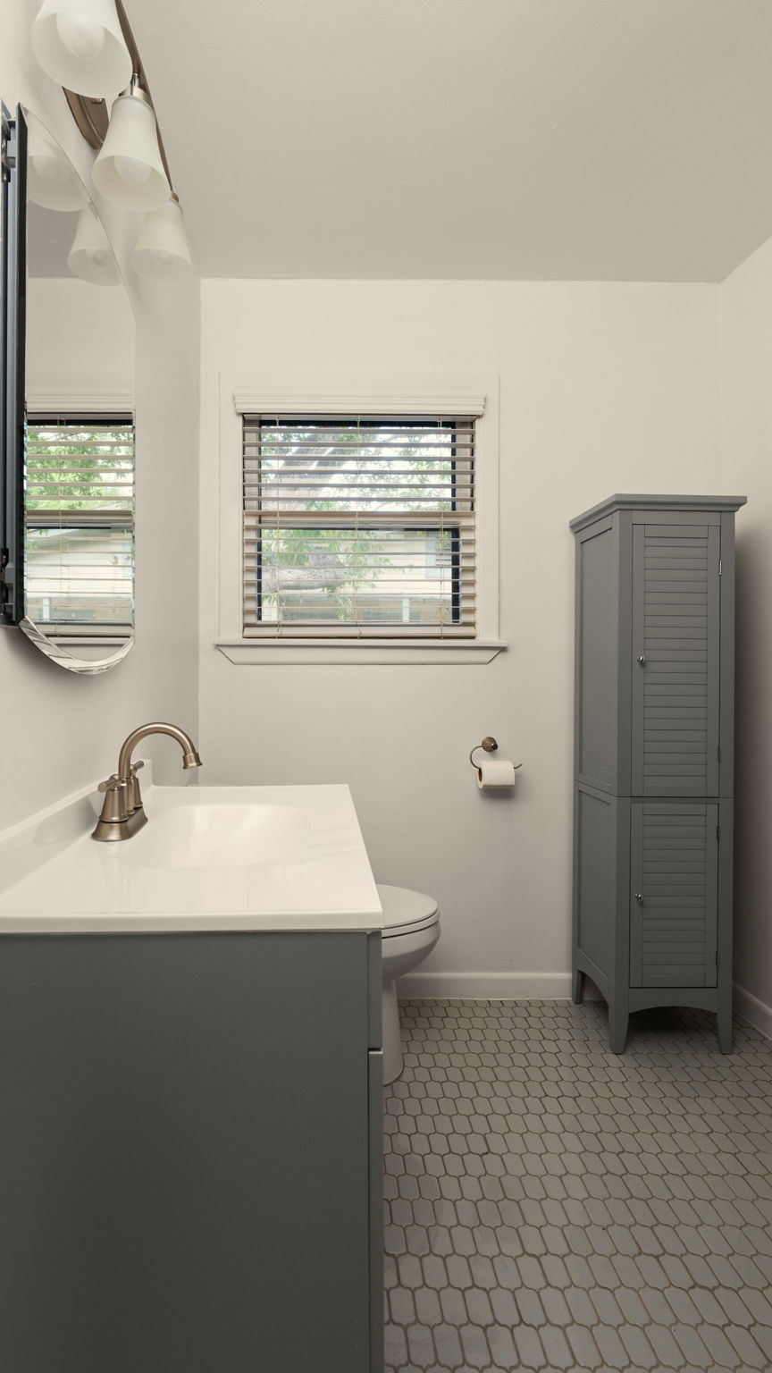 206 East Skyview Road Austin, TX 78752 - Photo 17 of 32 Refined bathroom with sleek vanity, a modern commode, and decorative storage.