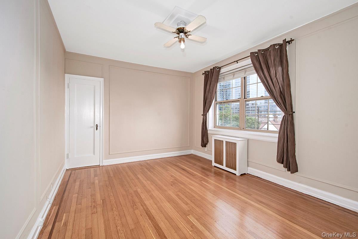 151 Centre Avenue, Unit 5D New Rochelle, NY 10805 - Photo 9 of 17 an empty room with wooden floor cabinet and windows