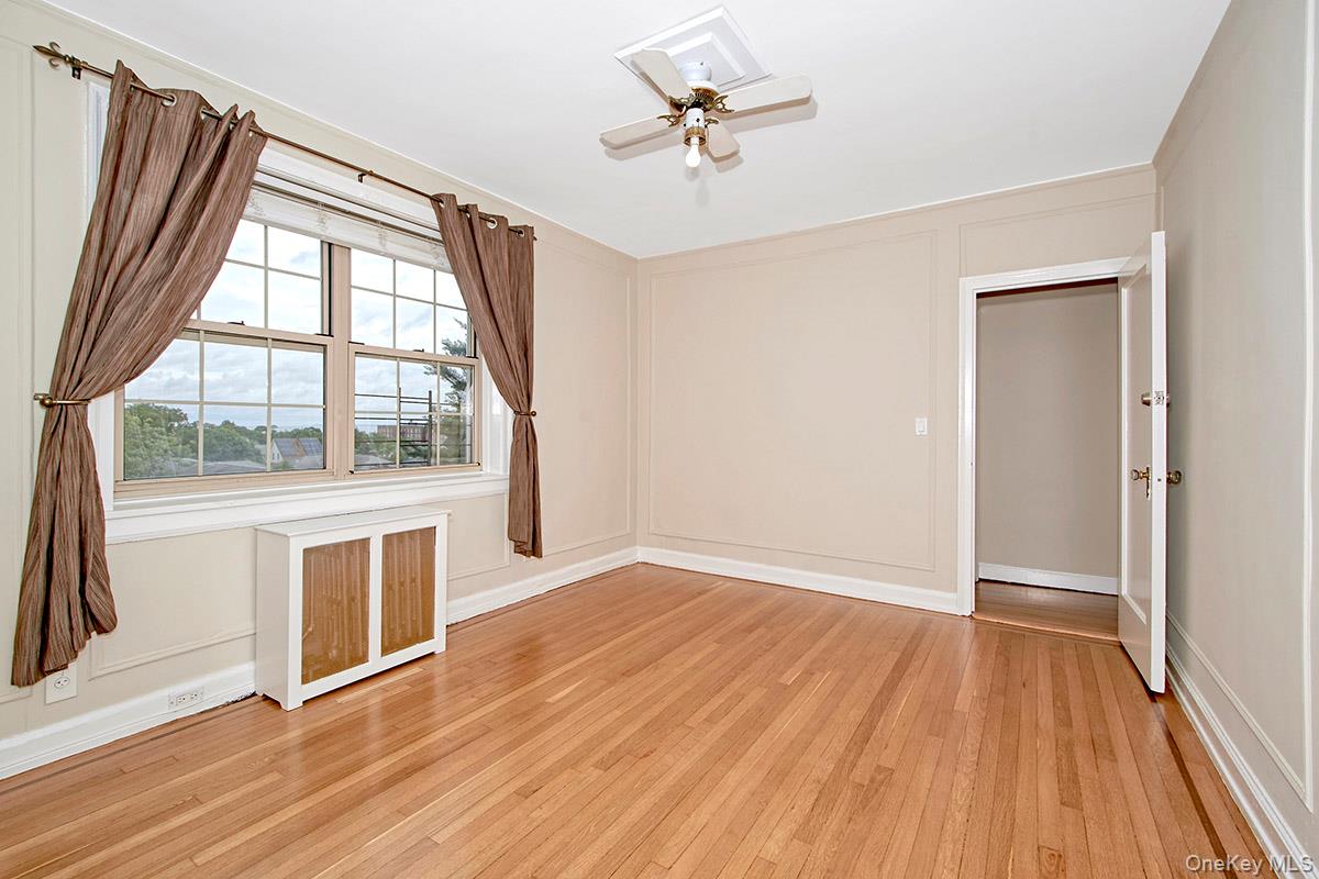 151 Centre Avenue, Unit 5D New Rochelle, NY 10805 - Photo 10 of 17 an empty room with wooden floor and windows
