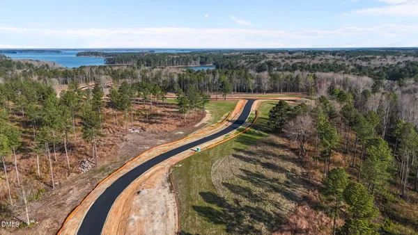 an aerial view of a house with a yard and lake view