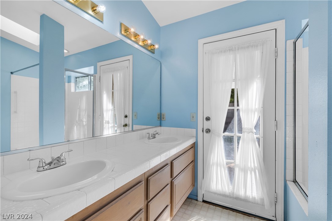 212 Pocahontas Court Henderson, NV 89074 - Photo 21 of 28 primary bathroom vanity and exit to the backyard