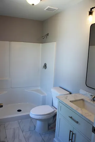 a bathroom with a sink a toilet and shower