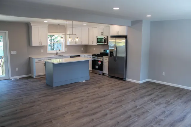 a kitchen with stainless steel appliances granite countertop a refrigerator a sink and a stove