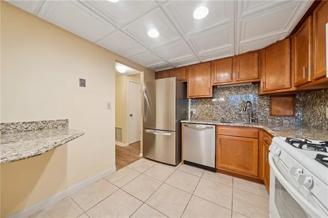 a kitchen with stainless steel appliances granite countertop a sink stove and refrigerator