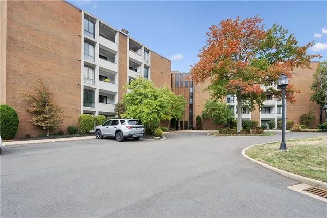 a view of a street with a building and trees in the background