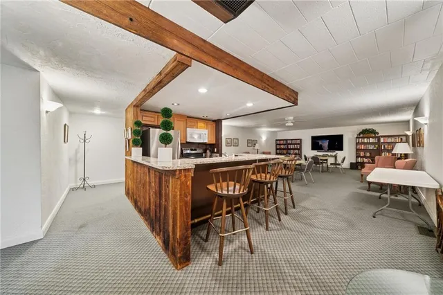 a living room with lots of furniture and view of kitchen