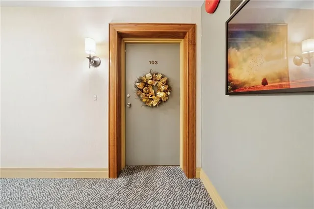 a view of a hallway view with wooden floor and a wall painting