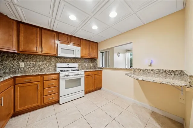 a kitchen with granite countertop cabinets stainless steel appliances and a counter space