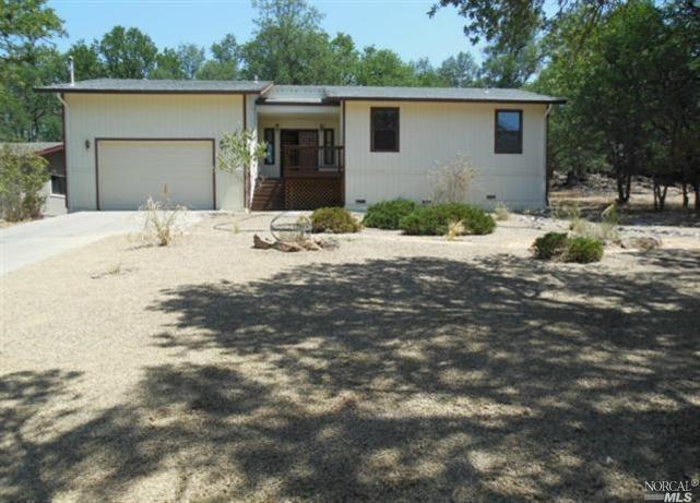 19186 Moon Ridge Road Hidden Valley Lake, CA 95467 - Photo 1 of 1 a front view of a house with a yard covered with trees