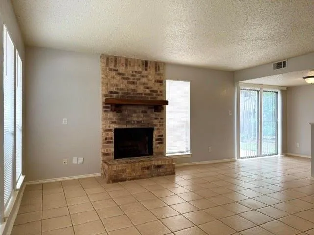 a view of an empty room with glass door and wooden floor