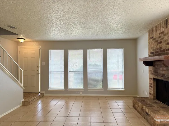 a view of an empty room with a fireplace and a window