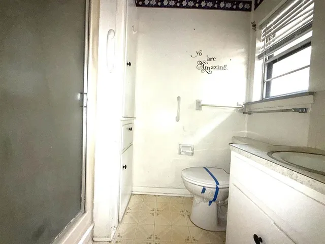 a bathroom with a toilet and a shower