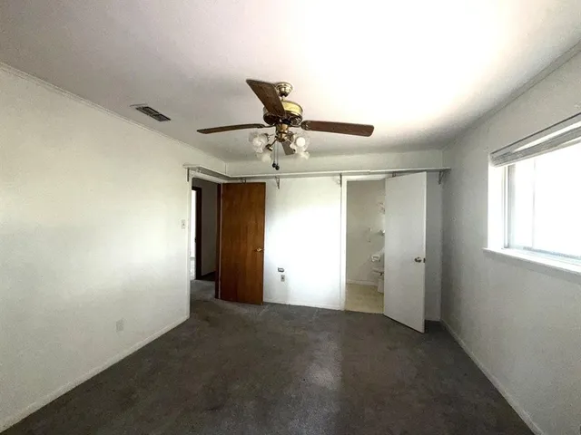 a view of a livingroom with a ceiling fan and window
