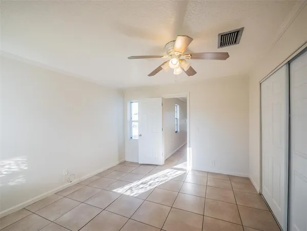 a view of an empty room and chandelier fan