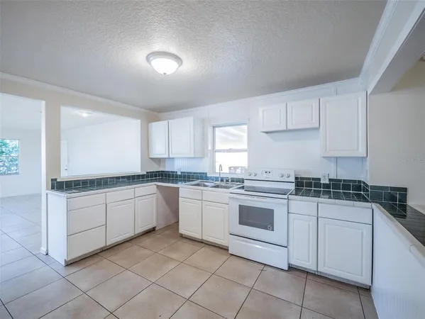 a kitchen with white cabinets appliances and a sink