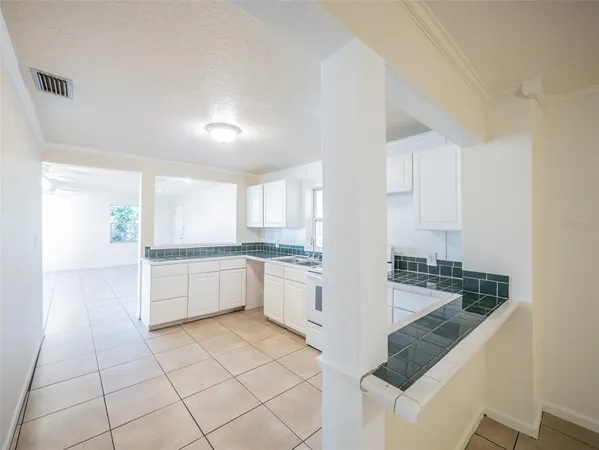 a large white kitchen with a sink and cabinets