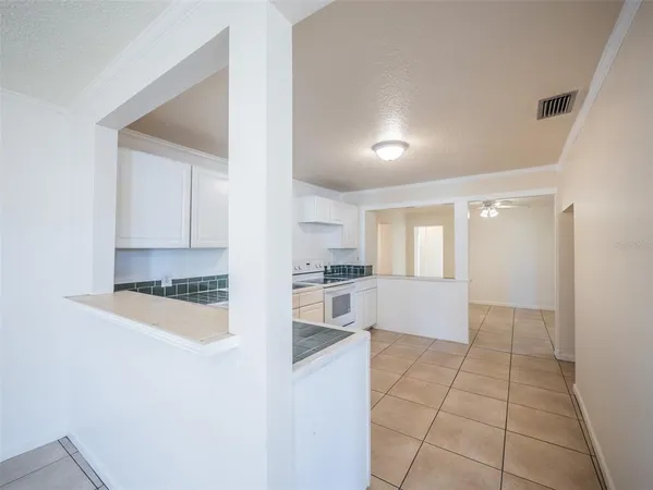 a kitchen with granite countertop a refrigerator and a stove top oven