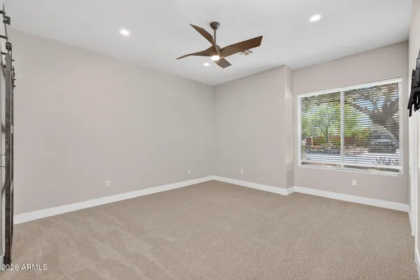 a view of a room with wooden floor ceiling fan and window