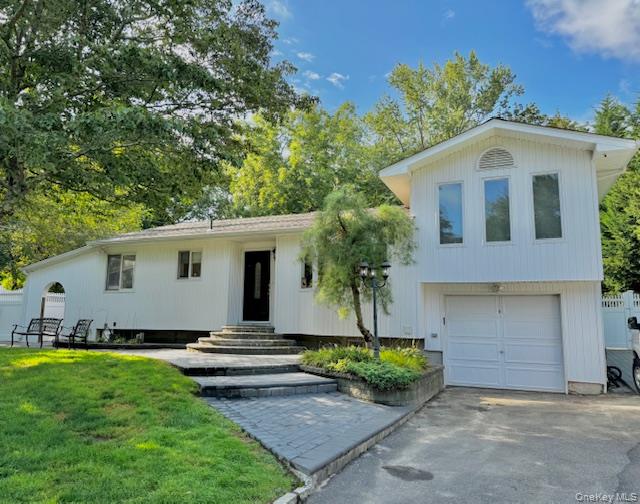 4 Halliday Road Coram, NY 11727 - Photo 1 of 19 a front view of a house with a garden and yard