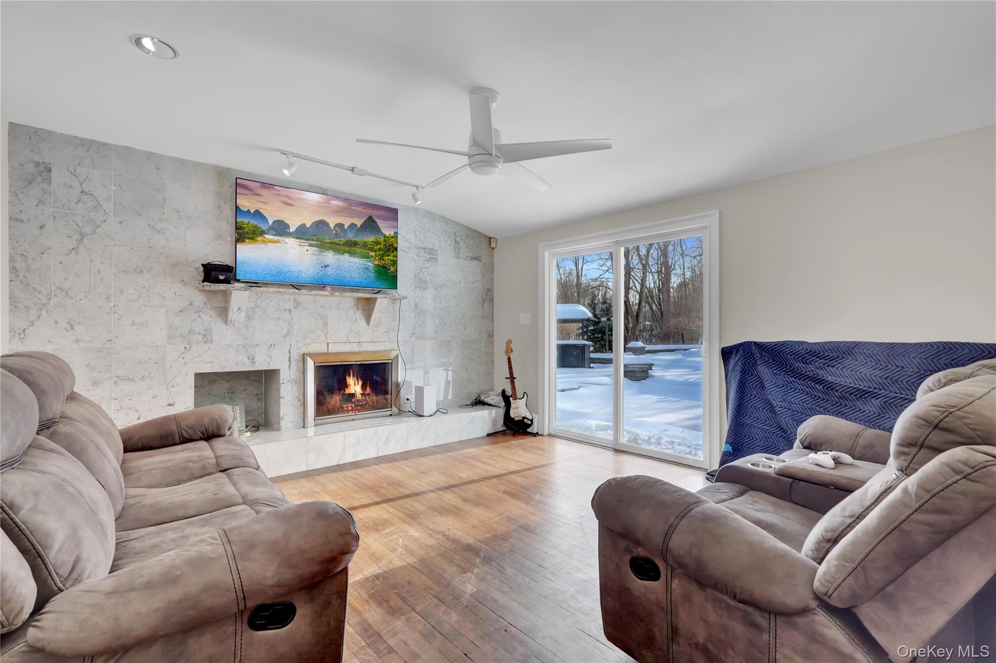4 Halliday Road Coram, NY 11727 - Photo 12 of 28 a living room with furniture a flat screen tv and a fireplace