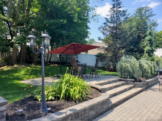 4 Halliday Road Coram, NY 11727 - Photo 4 of 19 a view of a patio with chairs and a table and chairs under an umbrella