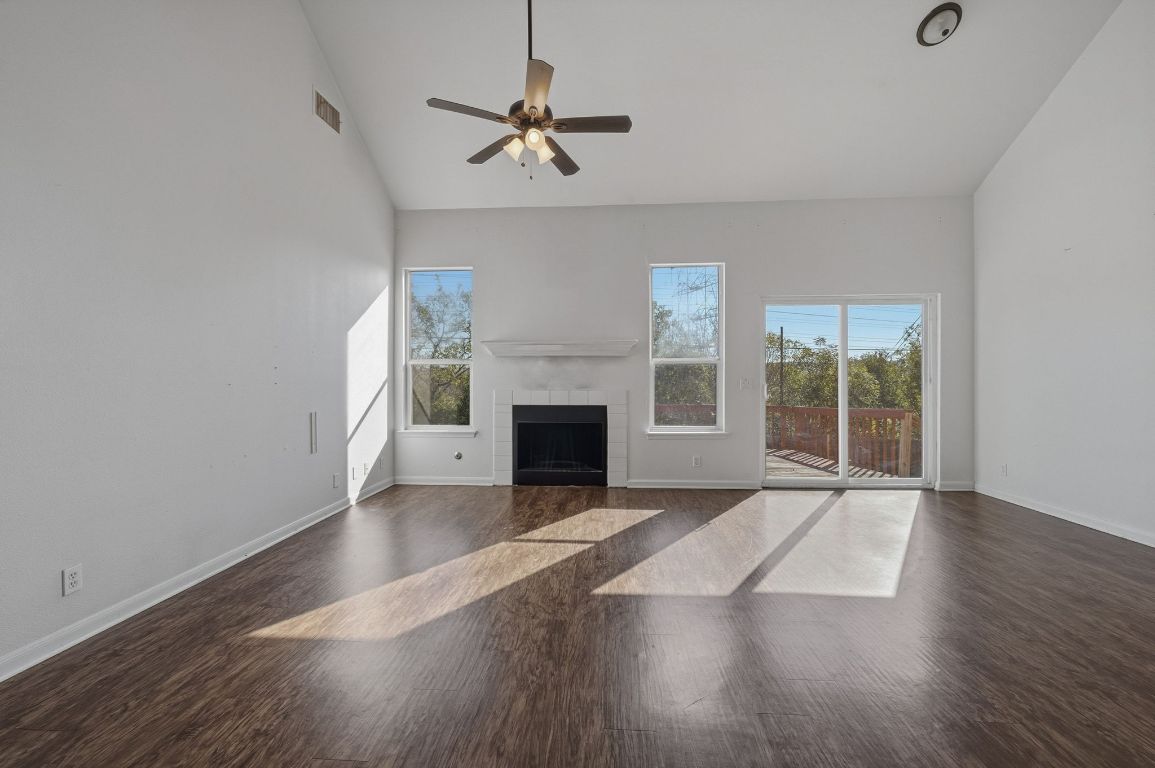 5237 Coppermead Lane Austin, TX 78754 - Photo 12 of 25 a view of an empty room with wooden floor fireplace and a window