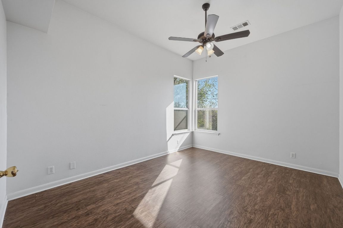 5237 Coppermead Lane Austin, TX 78754 - Photo 5 of 25 an empty room with wooden floor fan and windows