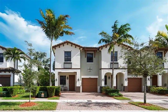 a palm tree sitting in front of a house with a yard